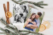 Load image into Gallery viewer, A photo of a double-sided Christmas card showing the front and back of the card laying on a white surface. Around the two sides of the card are pine needles, cinnamon sticks and dried oranges. The front of the card features a photo and the words “Comfort in Joy, The Thompsons” in white over the photo. The back of the card features two photos.