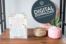 Load image into Gallery viewer, A card on a wood tabletop and on the right side of the card is a woven basket, a pink plant pot with a cactus in it and a pink crystal rock. The card features the words “Thank You Mom” with illustrated plant leaves. The words &quot;digital download&quot; are featured in a circle on top of the image.