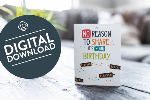 A greeting card featured on a black, wood coffee table. There’s a white planter in the background with a green plant. There’s also a gray sofa in the background with a white pillow. The card features the words “No reason to share it’s your birthday!” The words 