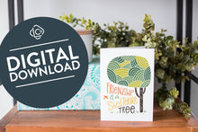 Load image into Gallery viewer, A greeting card is on a table top with a present in blue wrapping paper in the background. On top of the present is a candle and some greenery from a plant too. The card features the words “Friendship is a sheltering tree” with an illustrated tree. The words &quot;digital download&quot; are featured in a circle on top of the image. 