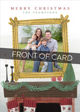 Load image into Gallery viewer, A close up of the front of the card showing the front of the card design. Across the image is a gray strip with the words “front of card” on it. The front of the card features the words “Merry Christmas” with a family name below it that can be edited. A photo is featured in an illustrated frame above an illustrated fireplace.