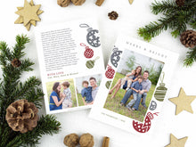 Load image into Gallery viewer, A photo of a two-sided Christmas card showing the front of the card on top of a brown wrapped gift on a white tabletop. Around the gift are pine needles, pinecones and wood star ornaments. The front of the card features a photo with the words Merry & Bright at the top and illustrated ornaments around the photo. The back of the card features two photos, illustrated ornaments and space to write a family update.