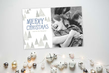 Load image into Gallery viewer, A photo of a one-sided Christmas card showing the front and back of the card laying on a white surface. To the bottom of the cards are silver and white small ornaments. The card features a photo on the right side and to the left side are the words “Merry Christmas” with a family name below it that you can edit. Around the words are whimsical illustrated pine trees.
