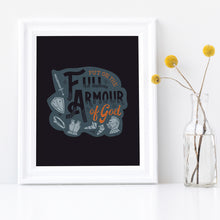 Load image into Gallery viewer, A framed print sits on a white shelf next to a vase of yellow flowers. The print features the quote 'Put on the full armour of God' in black and orange typography, with medieval-style pieces of armour illustrated in pale gray.