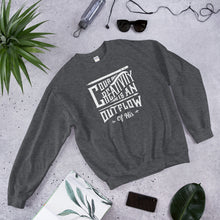 Load image into Gallery viewer, A dark grey sweatshirt laying on the ground with objects around it. The sweatshirt features hand drawn lettering in white with the words &quot;Our creativity is an outflow of His.&quot;