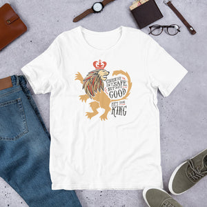 A white short sleeved T-shirt laying flat with objects around it. The T-Shirt features hand drawn illustration of the Chronicles of Narnia lion character Aslan. Inside the illustration there is the quote "Course He Isn't Safe, But He's Good. He's the King."