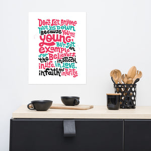 A white print hanging on a wall above a kitchen counter. The print has lettering in red, blue and black and reads "Don't let anyone put you down because you are young, but set an example for the believers, in speech, in life, in love, in faith and in purity."