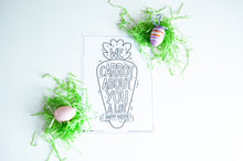 Load image into Gallery viewer, A coloring sheet on a white tabletop. There’s fake Easter grass around the color page. The card features the words “We carrot about you a lot, Happy Easter,” all featured in an illustrated carrot.