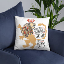 Load image into Gallery viewer, A white square pillow on a dark navy sofa. The artwork features hand drawn illustration of the Chronicles of Narnia lion character Aslan. Inside the illustration there is the quote &quot;Course He Isn&#39;t Safe, But He&#39;s Good. He&#39;s the King.&quot;