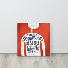Load image into Gallery viewer, A red wall art canvas leans against a pale grey wall. The canvas design features the outline of a person in white, filled with light grey doodles. The words ‘There’s something in you the world needs&#39; are lettered in black across the person’s chest.