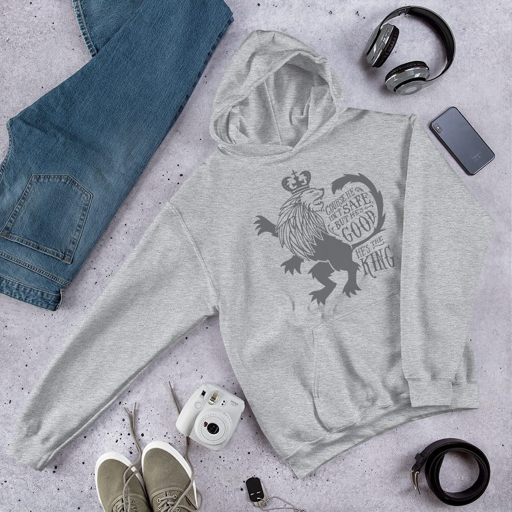 A light grey hoodie laying on the ground with objects around it. The hoodie features hand drawn illustration of the Chronicles of Narnia lion character Aslan. Inside the illustration there is the quote 