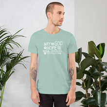 Load image into Gallery viewer, A man wearing a heather prism dusty blue color short sleeved t-shirt. The t-shirt features hand drawn lettering in white with the words &quot;May the God of hope fill you with all joy and peace as you trust him.&quot;