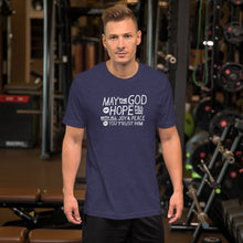 Load image into Gallery viewer, A man wearing a heather midnight blue color short sleeved t-shirt. The t-shirt features hand drawn lettering in white with the words &quot;May the God of hope fill you with all joy and peace as you trust him.&quot;