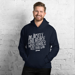 A man wearing a navy hoodie with the Bible verse words Do justly, love mercy, walk humbly, with your God, Micah 6:8 in white lettering. 
