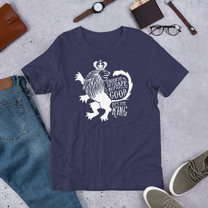 A navy short sleeved T-shirt laying flat with objects around it. The T-Shirt features hand drawn illustration of the Chronicles of Narnia lion character Aslan. Inside the illustration there is the quote "Course He Isn't Safe, But He's Good. He's the King."
