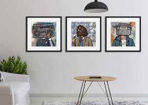 Three black frames featured in a living room. The frames include three different prints of vintage radios. 