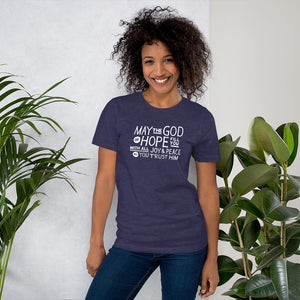 A woman wearing a heather midnight blue color short sleeved t-shirt. The t-shirt features hand drawn lettering in white with the words "May the God of hope fill you with all joy and peace as you trust him."
