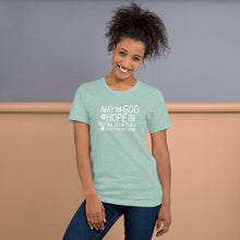 Load image into Gallery viewer, A woman wearing a heather prism dusty blue color short sleeved t-shirt. The t-shirt features hand drawn lettering in white with the words &quot;May the God of hope fill you with all joy and peace as you trust him.&quot;