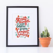 Load image into Gallery viewer, Artwork in a black frame with the with a white matte. The frame is leaning on a white counter with a terracota pot with a catcus next to it. The artwork features hand drawn lettering with the phrase &quot;Great things never come from comfort zones.&quot;