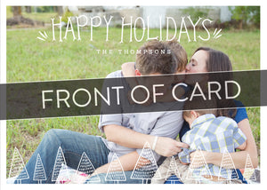 A close up of the front of the card showing the front of the card design. Across the image is a gray strip with the words “front of card” on it. The front of the card features a photo and the words “Happy Holidays, The Thompsons” in a front font on top and the bottom of the card has whimsical illustrated pine trees. 