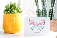 Load image into Gallery viewer, A greeting card is on a table top with a yellow plant pot and a green plant inside. The card features the words “Therefore if anyone is in Christ, the new creation has come. The old has gone. The new is here. 2 Corinthians 5:17.” The card design features an illustrated butterfly. 