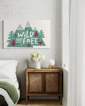 Load image into Gallery viewer, A large white flag featured on a wall of a bedroom. The white flag features the words &#39;wild and free&#39; inside illustrated mountains with sketch trees and other elements around.