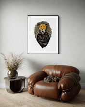 Load image into Gallery viewer, Artwork in a black frame with the with a white matte. The frame is on a wall above a brown sofa chair. The artwork features an illustrated Aslan (the lion from Chronicles of Narnia). Inside the lion the Narnia quote is featured reading “At The Sound of Your Roar, Sorrows Will Be No More.”