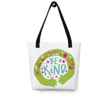 Load image into Gallery viewer, A white tote bag with black handles on a white background. The bag features a design with the words &#39;be kind&#39; with illustrated hugging hands around the words. 