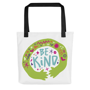 A white tote bag with black handles on a white background. The bag features a design with the words 'be kind' with illustrated hugging hands around the words. 