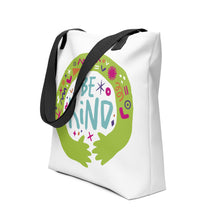 Load image into Gallery viewer, A side view of a white tote bag with black handles on a white background. The bag features a design with the words &#39;be kind&#39; with illustrated hugging hands around the words. 