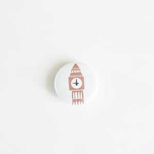 A button on white tabletop. The button features an illustration of Big Ben. 