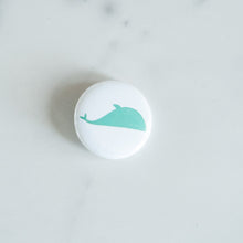 Load image into Gallery viewer, A button on a white tabletop. The button features an illustration of a whale. 