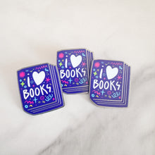 Load image into Gallery viewer, Three enamel pins with the words &#39;I love books&quot; with the word love shown as a heart. The words are featured inside an illustrated book, all in bright fun colors. 