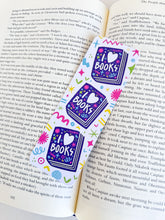 Load image into Gallery viewer, A bookmark placed inside a book. The bookmark features the words &quot;i love books&quot; with love shown shaped as a heart. The words are placed inside an illustrated book. 