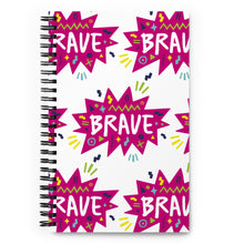 Load image into Gallery viewer, A spiral notebook is on a tabletop. The white spiral notebook has black spiral binding. The pattern design features the word &quot;brave&quot; inside a hot pink star with sketchy elements around. 