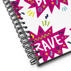 A close up of the spiral notebook binding. The pattern design features the word "brave" inside a hot pink star with sketchy elements around. 