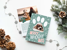 Load image into Gallery viewer, A photo of a double-sided Christmas card showing the front and back of the card laying on a white surface. Around the two sides of the card are pine cones, pine needles and a string of silver snowflake garland. The front of the card features a photo inside a paw shaped frame. Around the photo are white stars and below are the words “Merry Woofmas.” The back of the card features one photo with a dog paw illustration and space to add an update. 