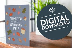 A photo of a card featured on a tabletop next to a white planter filled with a green plant. ​​The card features the words "Thank You for a Welcoming Table" with illustrated leaves and acorns around the words. The words "digital download" are featured in a circle over the image.