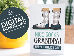 A greeting card is on a table top with a yellow plant pot and a green plant inside. The card features the words “Nice Socks Grandpa, Happy Father’s Day” with an illustrated of legs with patterned socks and shoes. The words "digital download" are featured in a circle on top of the image.