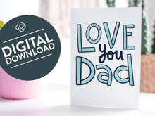 Load image into Gallery viewer, A greeting card featured standing up on a white tabletop with a pink plant pot in the background and some succulents in the pot. There’s a woven basket in the background with a cactus inside. The card features the words “Love You Dad” in simple typography. The words &quot;digital download&quot; are featured in a circle on top of the image. 