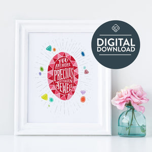 The words "digital download" are featured over the image. Artwork in a white frame with the with a white matte. The frame is leaning on a white counter with a pink flower in a blue case next to it. The artwork features an illustrated jewel with the words inside "You are more precious than jewels." There is a scattering of illustrated, colored jewels around the image.