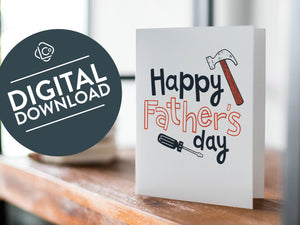 A card on a wood tabletop with an object in the background that is out of focus. The card features the words “Happy Father’s Day” with an illustrated hammer and screwdriver around the words. The words "digital download" are featured in a circle on top of the image. 