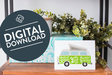 Load image into Gallery viewer, A greeting card is on a table top with a present in blue wrapping paper in the background. On top of the present is a candle and some greenery from a plant too. The card features the words “Difficult roads often lead to beautiful destinations” with an illustrated campervan. The words &quot;digital download&quot; are featured in a circle on top of the image. 