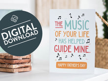 Load image into Gallery viewer, A greeting card featured standing up on a white tabletop with a framed photo of a succulent in the background and a stack of wooden coasters. There’s a woven basket in the background with a cactus inside. The card features the words “The music of your life has helped guide mine. Happy Father&#39;s Day.” The words &quot;digital download&quot; are featured in a circle on top of the image. 