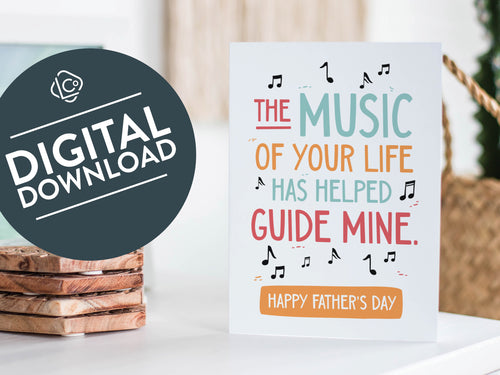 A greeting card featured standing up on a white tabletop with a framed photo of a succulent in the background and a stack of wooden coasters. There’s a woven basket in the background with a cactus inside. The card features the words “The music of your life has helped guide mine. Happy Father's Day.” The words 