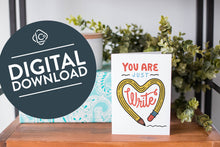 Load image into Gallery viewer, A greeting card is on a table top with a present in blue wrapping paper in the background. On top of the present is a candle and some greenery from a plant too. The card features the words “You are just write”with an illustrated pencil in the shape of a heart.. The words &quot;digital download&quot; are featured in a circle on top of the image. 