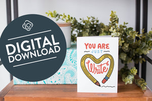 A greeting card is on a table top with a present in blue wrapping paper in the background. On top of the present is a candle and some greenery from a plant too. The card features the words “You are just write”with an illustrated pencil in the shape of a heart.. The words "digital download" are featured in a circle on top of the image. 