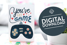 Load image into Gallery viewer, A greeting card is on a table top with a gift in pink wrapping paper. Next to the gift is a white plant pot with a green plant. The card features the words “You’ve got game” with an illustrated gaming controller.. The words &quot;digital download&quot; are featured in a circle on top of the image. 