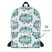 Load image into Gallery viewer, A backpack on a white background with a pattern design with the word &quot;dream&quot; inside a cloud illustration with sketchy elements. A note on the side shows the detail of the inside pocket. 