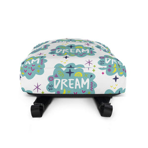 A backpack on a white background with a pattern design with the word "dream" inside a cloud illustration with sketchy elements. The backpack is laying down to show the bottom of the backpack.